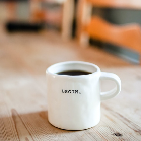 White Coffee Cup with the Word Begin on it